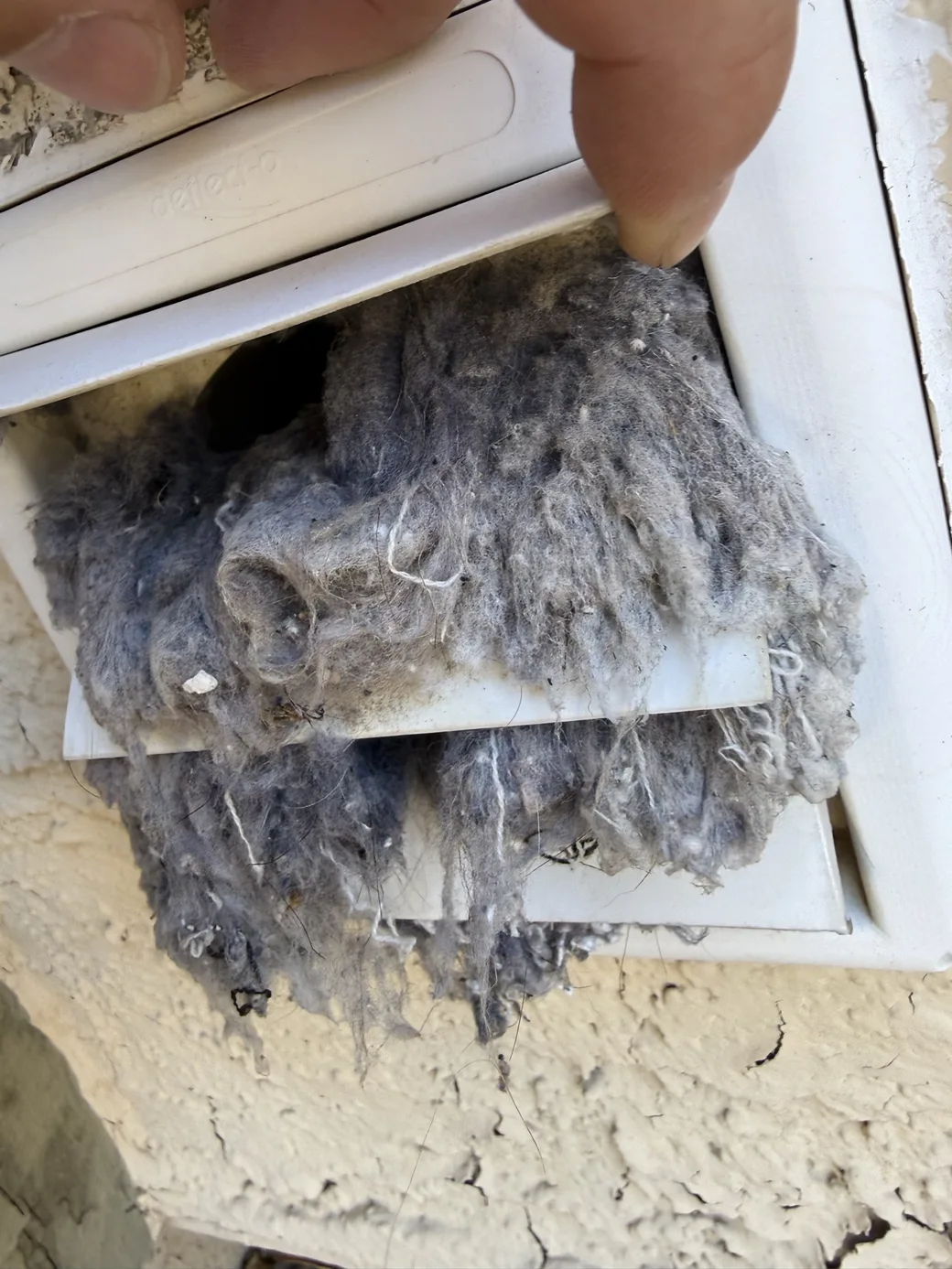 Lint accumulated on a removed appliance airflow component