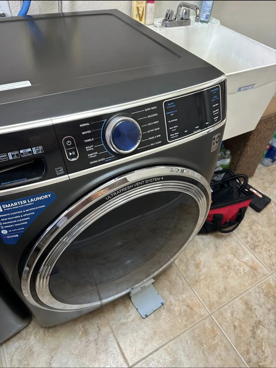 A dark GE front-loading washing machine with its controls and glass door visible