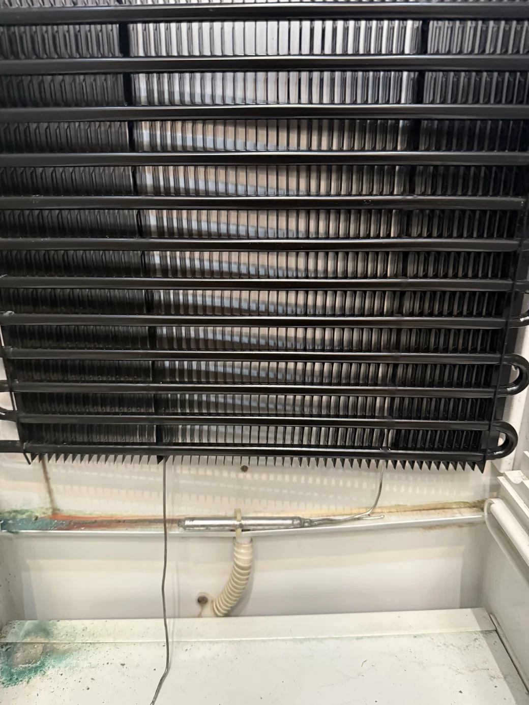 An exposed finned refrigeration coil and tubing inside an appliance